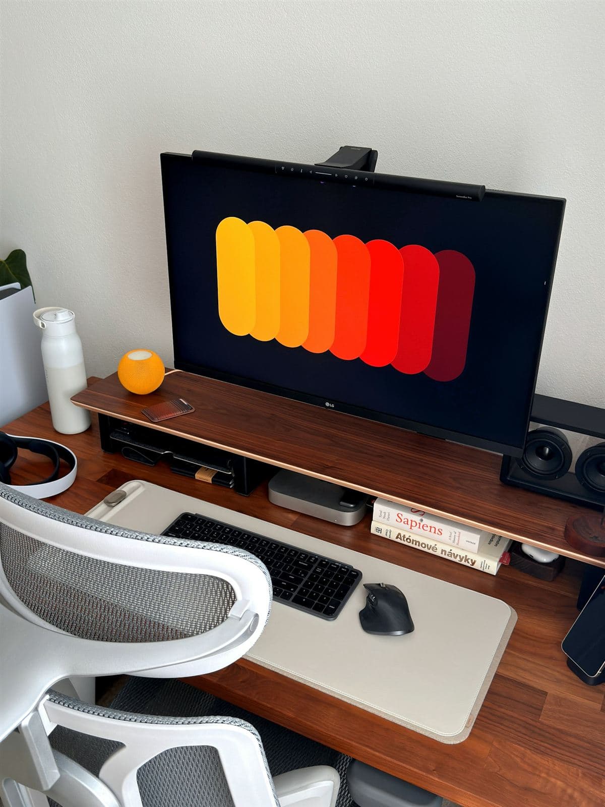 A desk with a monitor showing a colourful interface design